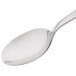 An Arcoroc stainless steel dinner spoon with a white handle.