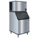 A stainless steel Manitowoc water cooled ice maker with a black lid.