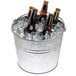 A bucket of beer bottles in ice with a Manitowoc Indigo NXT water cooled ice machine.