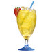 A glass of yellow liquid with a straw and a strawberry sitting next to a Manitowoc Indigo NXT water cooled ice machine.