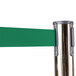 A brass Aarco crowd control stanchion with dual green retractable belts.