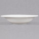 A close up of a CAC white porcelain fruit/monkey dish with a rim.
