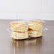 A Dart clear plastic high dome oblong container holding two scones.
