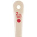 A Carlisle beige and red measure portion spoon with a red circle on the handle.