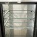 A metal middle shelf for an Avantco back bar refrigerator.