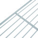 A close-up of a white metal wire shelf.