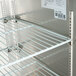 A metal shelf for an Avantco back bar refrigerator.