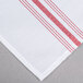 A red and white striped Snap Drape Softweave cloth napkin on a table.