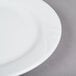 A close-up of a Tuxton Sonoma bright white china plate with an embossed white rim.