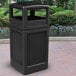 A black rectangular Commercial Zone waste container with an ashtray dome lid on a brick surface.