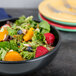 A Hall China black bistro bowl filled with salad with fruit.