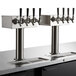 A Beverage-Air black kegerator with four silver taps on a counter.