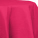 A hot magenta pink Creative Converting OctyRound table cover on a round table.