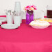 A table with a pink Creative Converting table cover, plates, and forks.