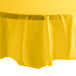 A yellow tablecloth with round edges on a table.