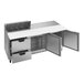 A stainless steel counter top with open doors and two drawers.