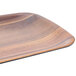 A Carlisle rectangular woodgrain melamine tray with black handles.