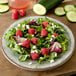 A Carlisle round smoke melamine salad plate with salad, raspberries, and cucumbers.