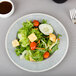 A Carlisle Smoke melamine salad plate with a salad of lettuce, tomatoes and croutons.