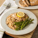 A Carlisle Grove melamine plate with rice, asparagus, and chicken with a lemon wedge on top.