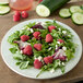 A Carlisle Grove melamine salad plate with a salad of raspberries and cucumbers.