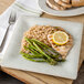 A Carlisle Grove melamine plate with rice, asparagus, and chicken with a lemon slice on top.
