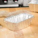 A clear dome lid on a silver foil bread loaf pan.