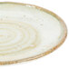 A white melamine salad plate with a speckled brown design.