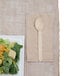 A plate of salad with a wooden dispenser napkin on the table.