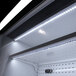 An open black Turbo Air air curtain merchandiser with shelves and lights inside.