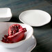 A Tuxton Artisan Agave china plate with a pomegranate on it.