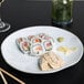 A Tuxton Artisan Agave china plate with sushi rolls and dumplings.