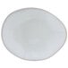 A white Tuxton Artisan china plate with an ellipse shape and a small hole in the middle.