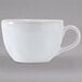 A white Tuxton china cup with a handle.