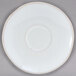 A close-up of a white Tuxton Artisan Agave saucer with a circular edge.