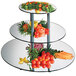 A Cal-Mil three tiered mirror riser with broccoli and carrots on the top two tiers.