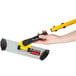 A hand holding a yellow and black Rubbermaid HYGEN microfiber mop handle.
