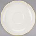 A CAC ivory saucer with a scalloped edge and yellow trim.