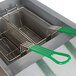 A Frymaster gas fryer with a green handle on a metal basket.