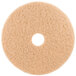 A white circular 3M tan burnishing floor pad with a hole in the middle.