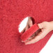A hand holding a 3M 13" red buffing floor pad.