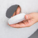 A hand holding a white 3M Super Polishing Floor Pad.
