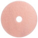 A white circle on a pink circular 3M burnishing pad.