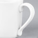 A close-up of a white Arcoroc porcelain mug with a handle.