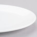 A close-up of a white Chef & Sommelier oval platter with a rim.