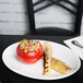 A Chef & Sommelier white bone china oval platter with a tomato stuffed with rice and grilled vegetables.