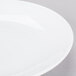 A close-up of a Chef & Sommelier white bone china plate on a white surface.