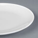 A close-up of a Chef & Sommelier white bone china plate with a small rim.