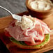 A sandwich with ham and cheese with AAK Select Recipe mayonnaise on a cutting board.