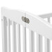 A white L.A. Baby Little Wood crib with metal hinges.